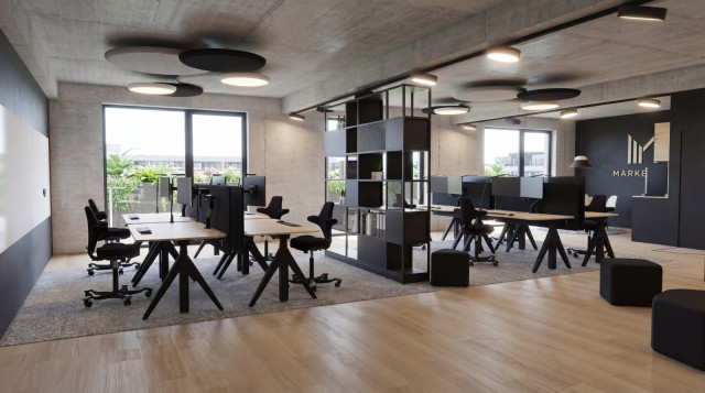 Modernes Open-Space-Büro im Greenhouse Senden mit ergonomischen Arbeitsplätzen, Sichtbetondecke, Holzboden und schallabsorbierenden Deckenelementen.