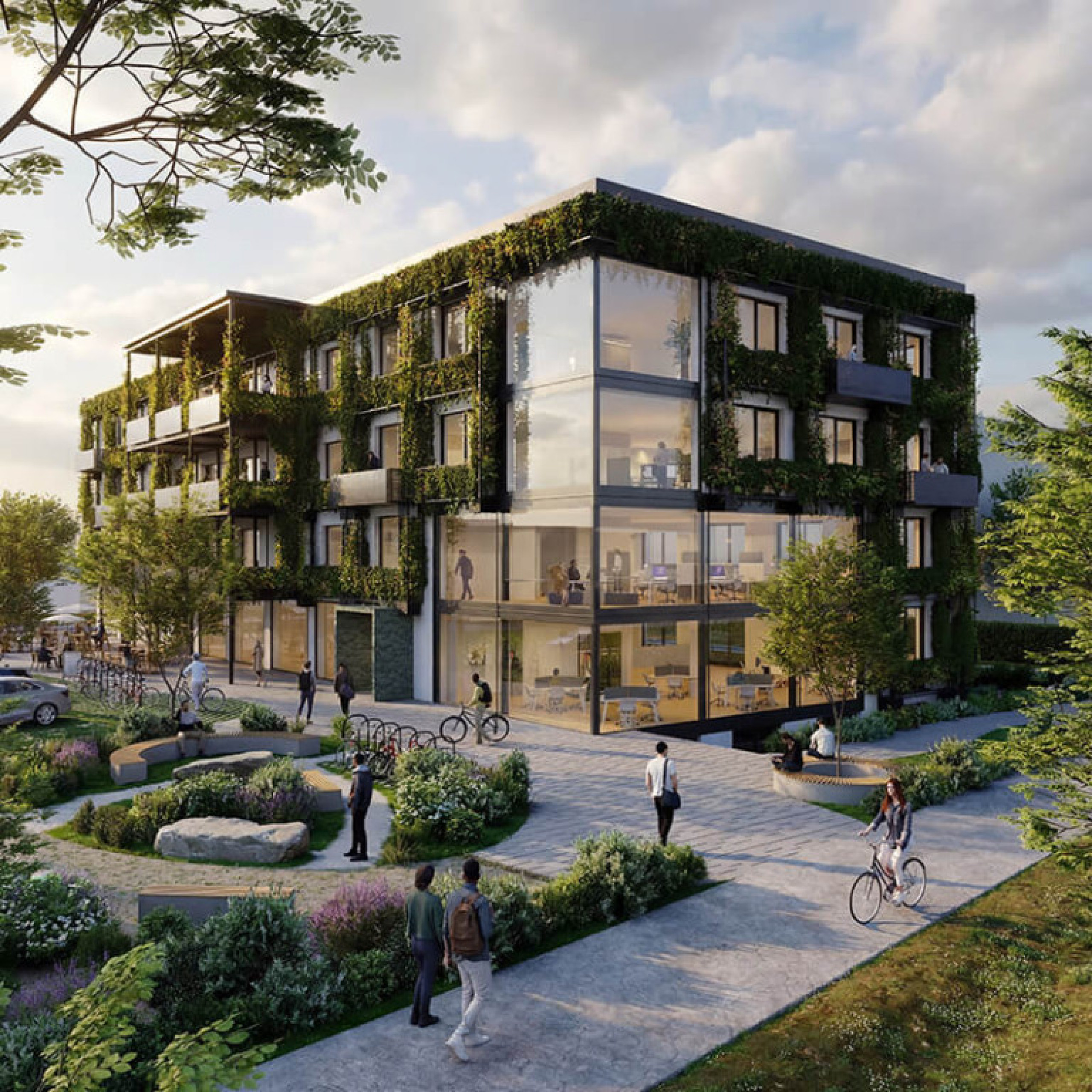 Modernes Coworking-GebÃ¤ude in Ulm mit begrÃ¼nter Fassade, Balkonen und groÃen Fenstern; vor dem GebÃ¤ude fahren einige Personen Fahrrad oder laufen auf einem Platz.